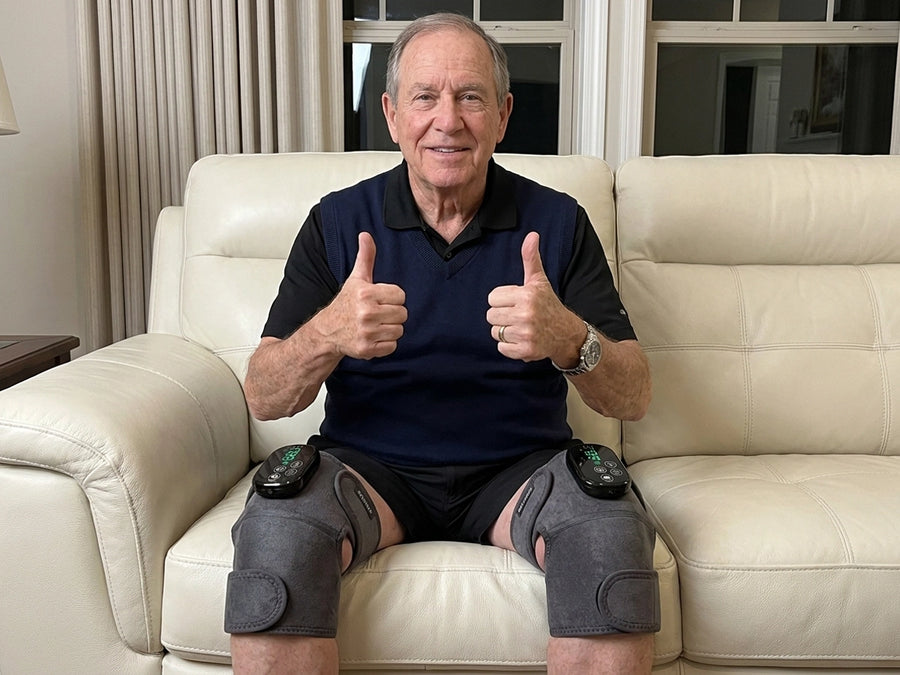 Senior man wearing Revimus Motion red light heated knee massagers on both knees at home